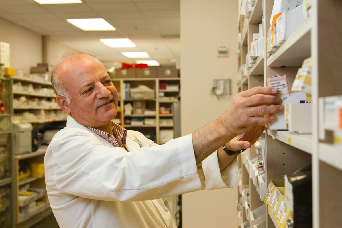 A pharmacist reviewing products on a shelf