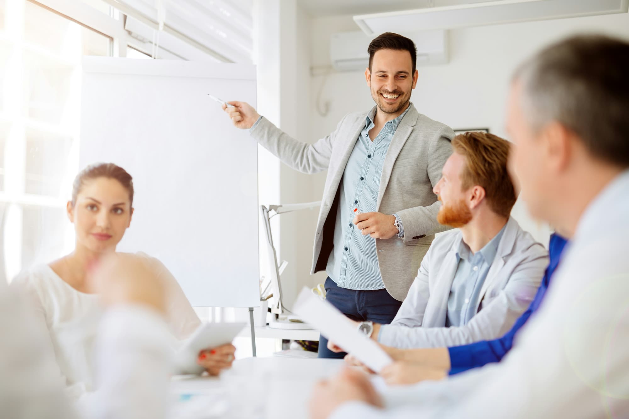 A presenter speaking to colleagues in a meeting