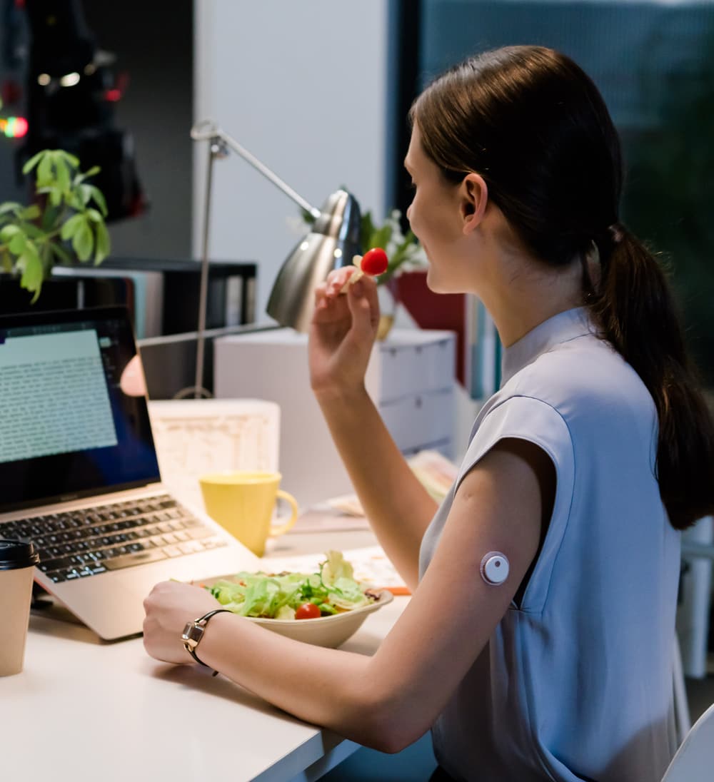 A woman at her desk wearing a LinX sensor