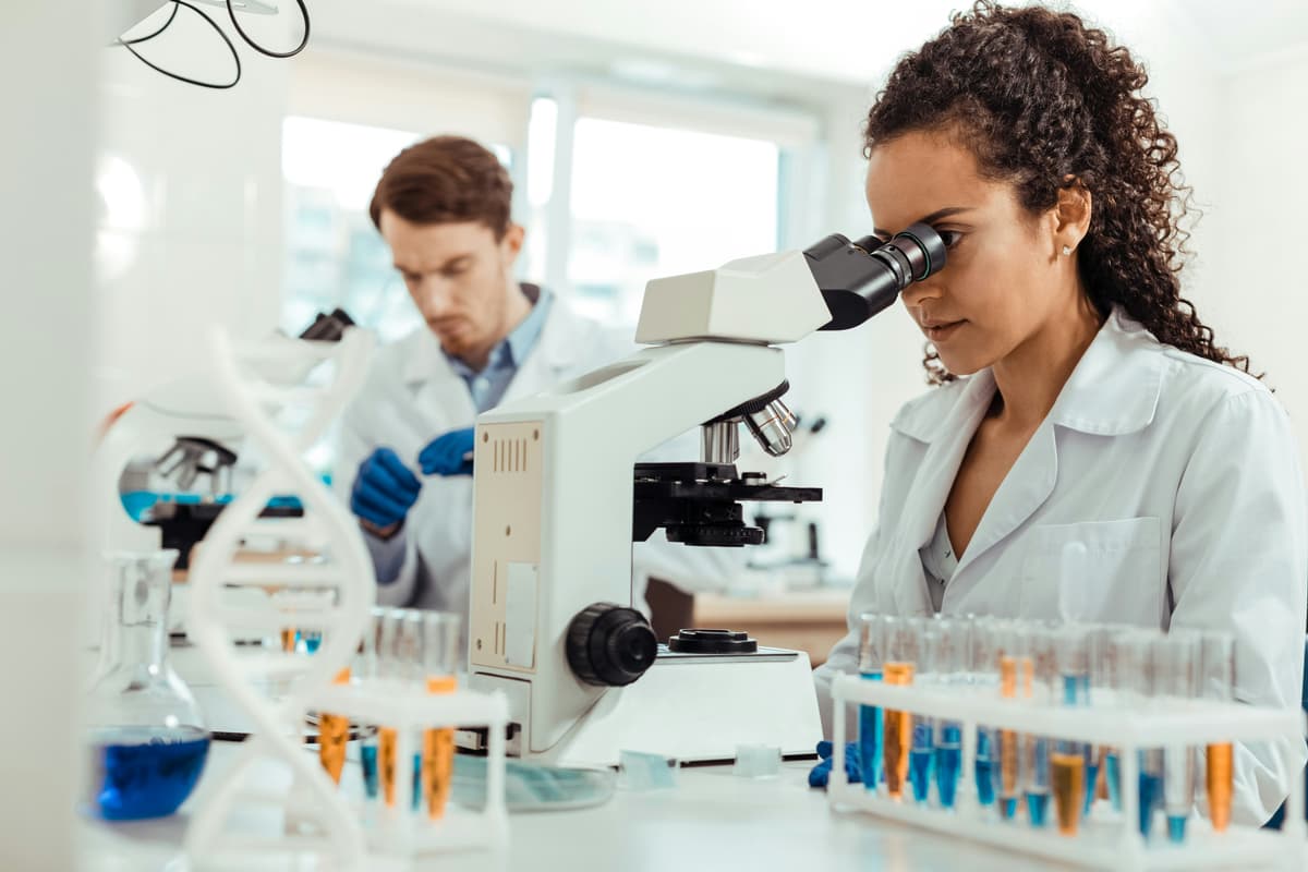 Two scientists working with a microscope in a laboratory