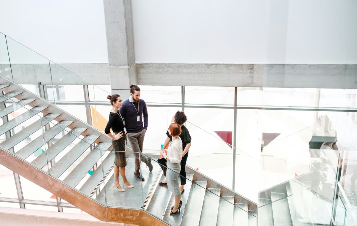 Healthcare professionals walking up a staircase in a bright atrium